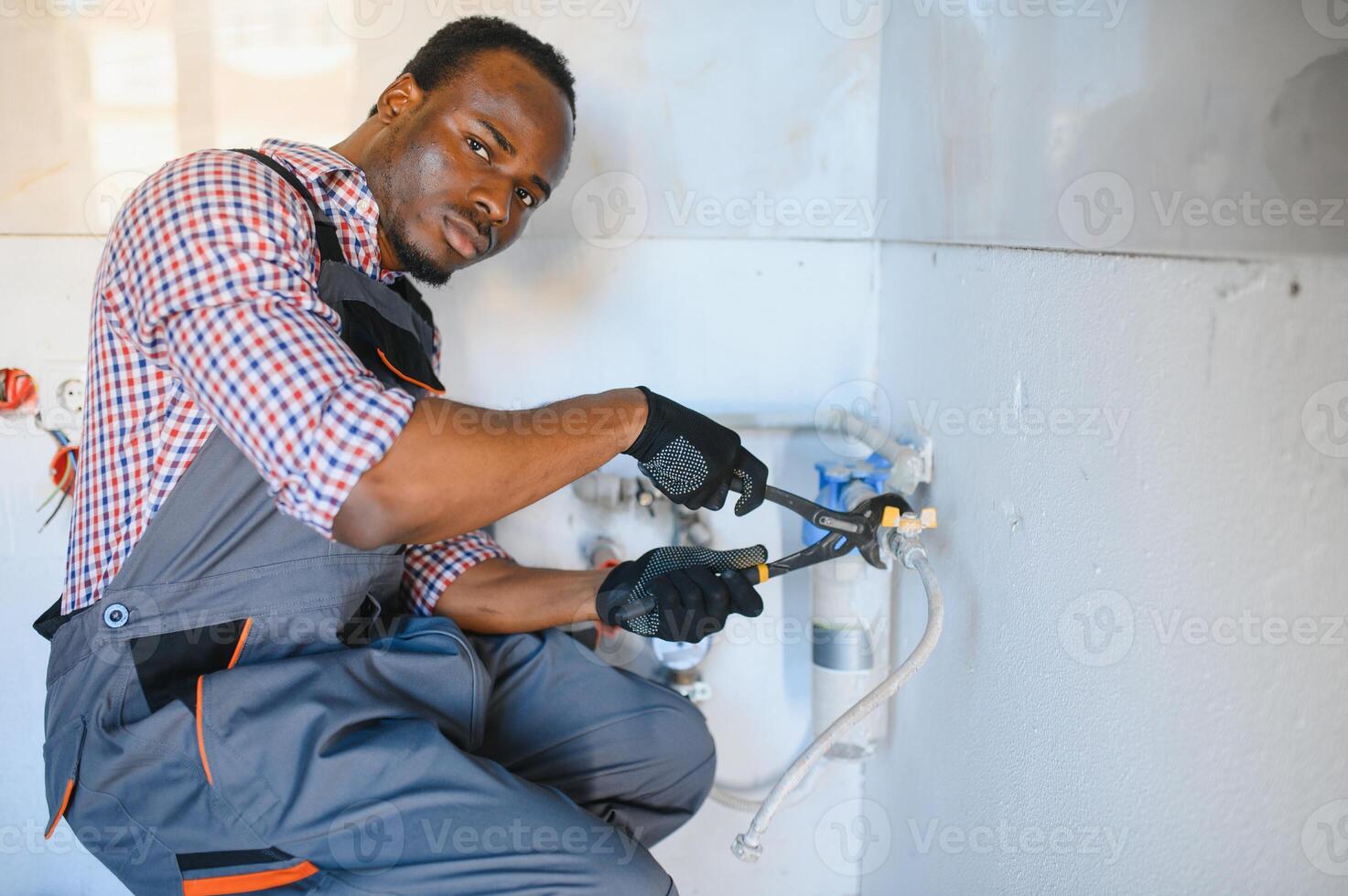 African American Plumber installs a water filter. water filter. photo