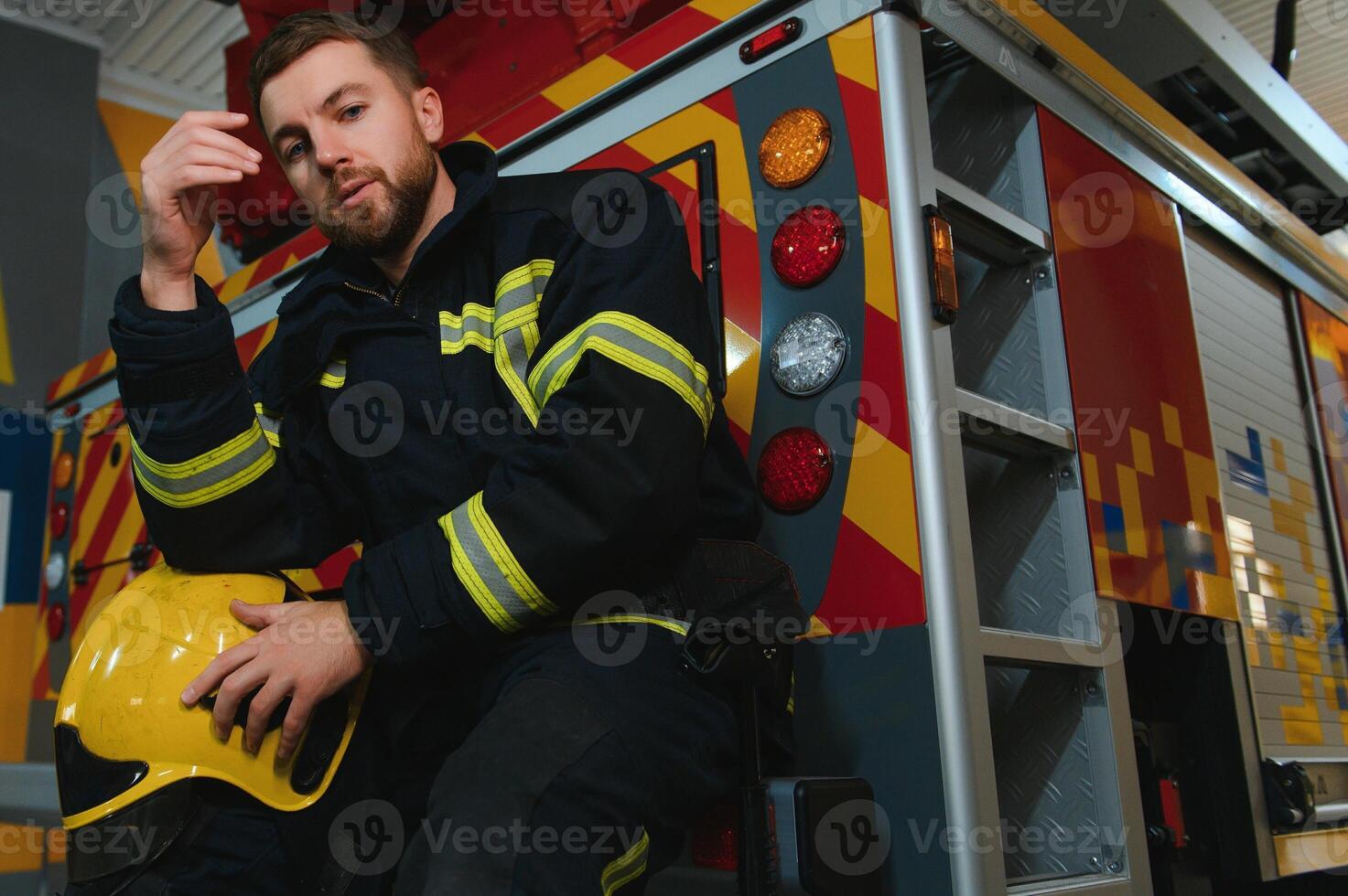 depressed and tired firefighter near fire truck photo