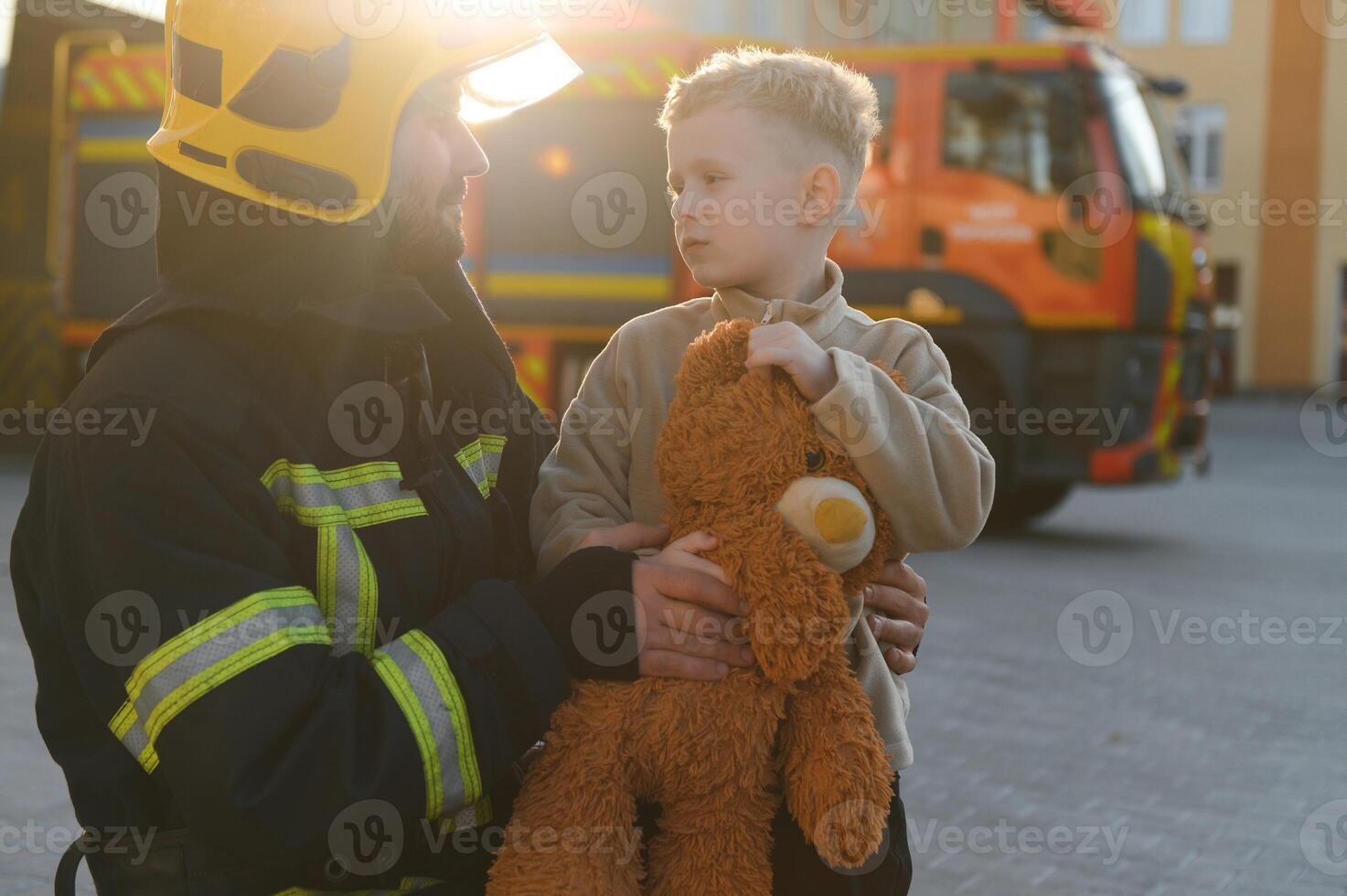 Firefighter holding child boy to save him in fire and smoke,Firemen rescue the boys from fire photo