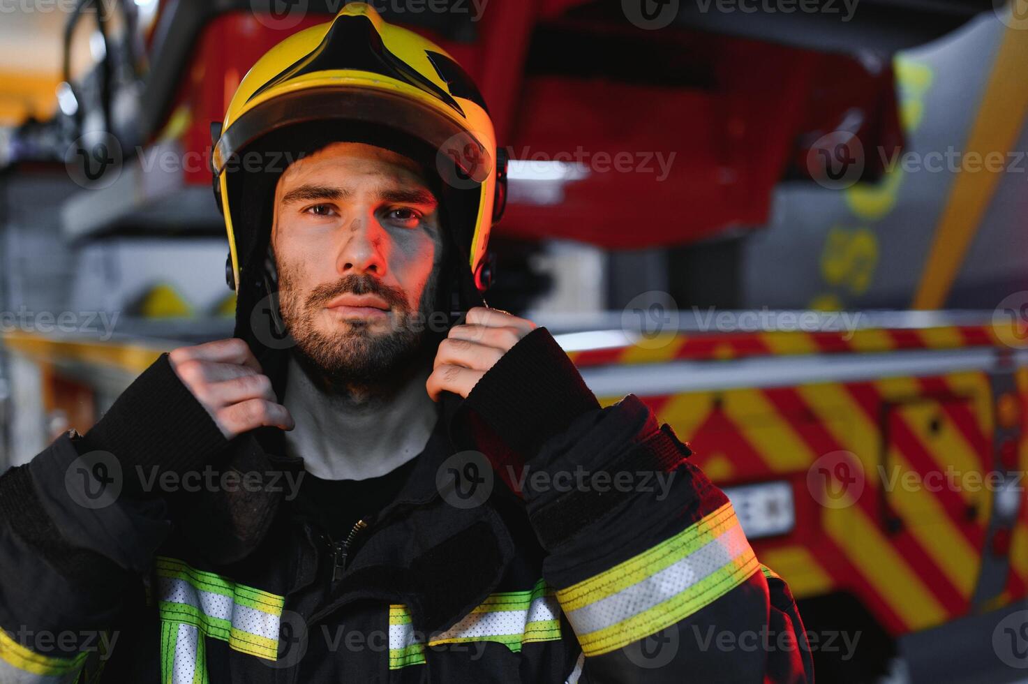 Firefighter portrait on duty. fireman with helmet near fire engine photo
