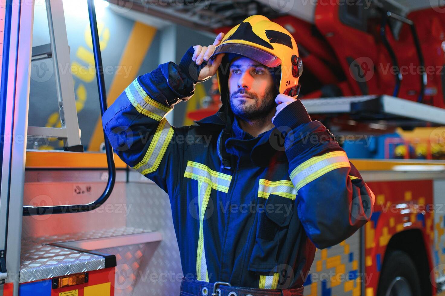 Portrait of male firefighter in uniform at fire station photo