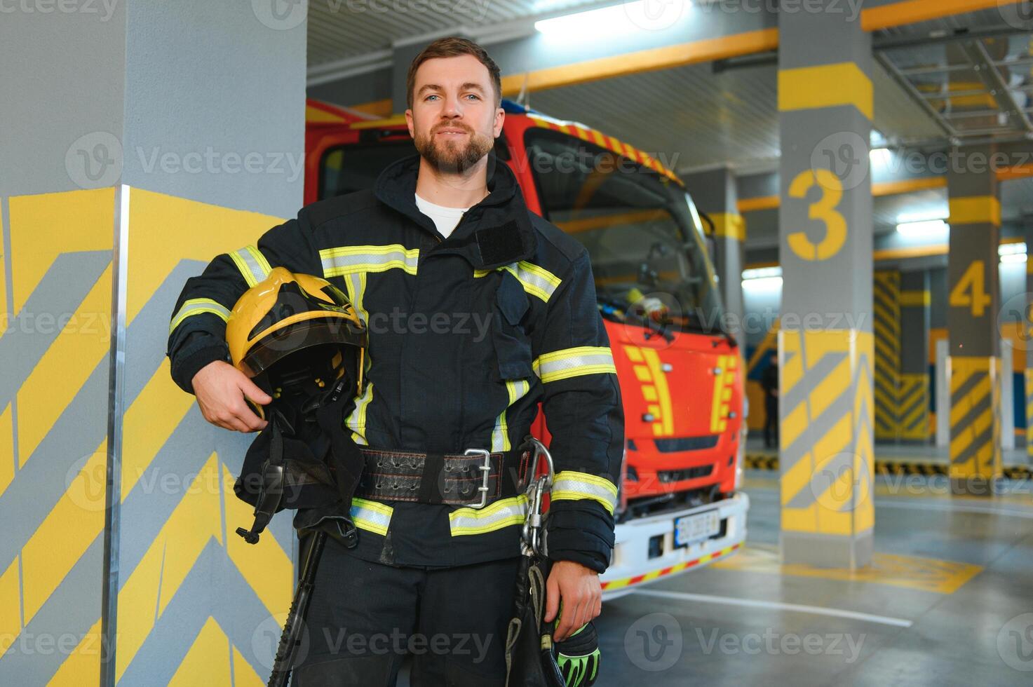 Portrait of male firefighter in uniform at fire station photo