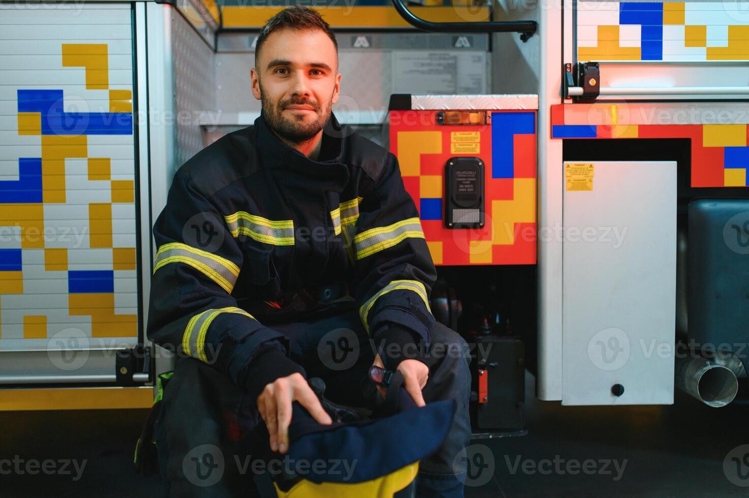Firefighter portrait on duty. fireman with helmet near fire engine photo