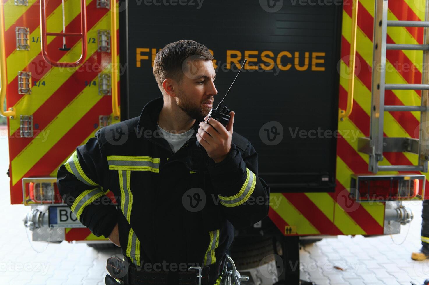Photo of fireman with gas mask and helmet near fire engine