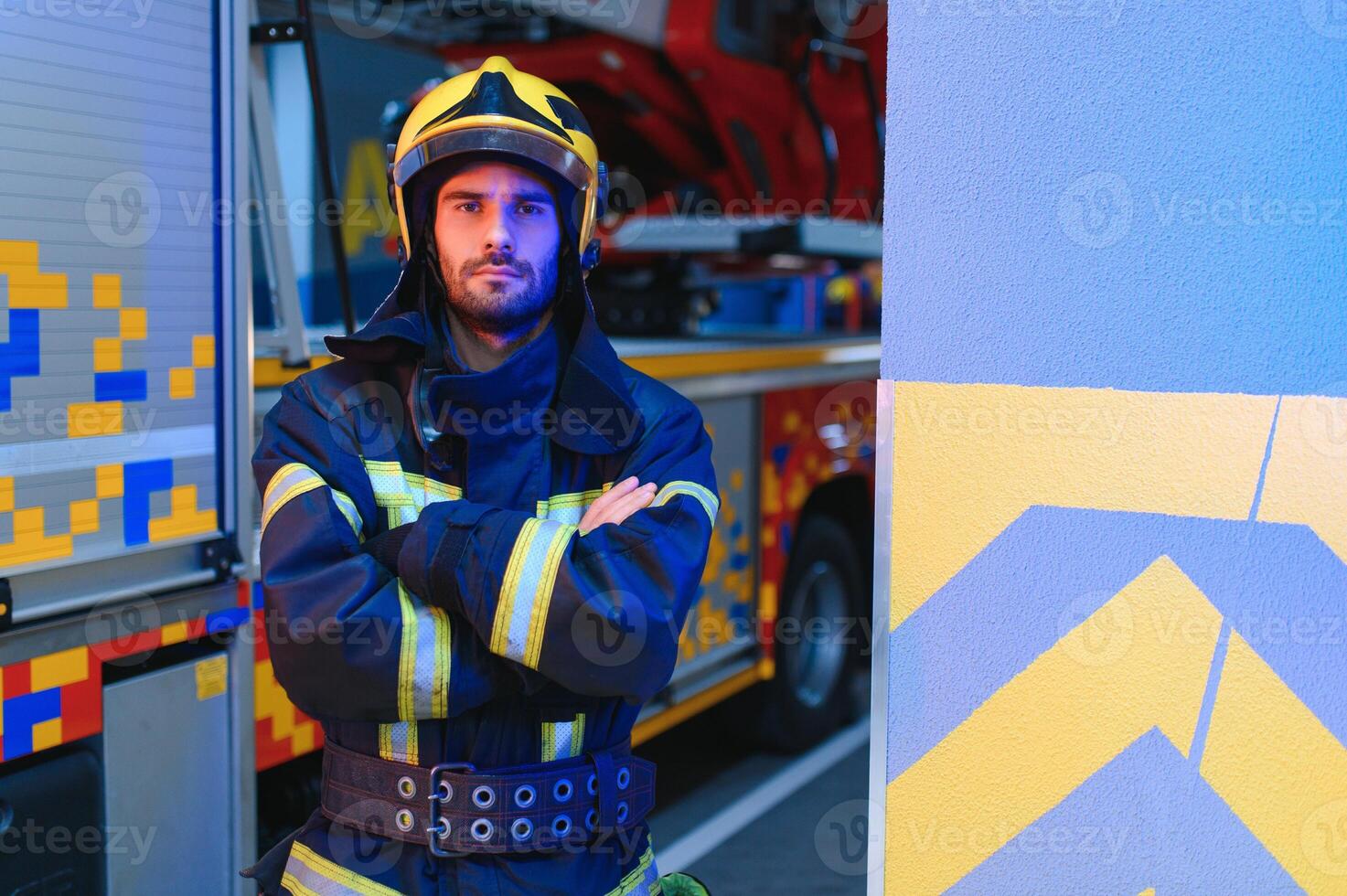 Firefighters man in a protective suit near fire truck. Protection, rescue from danger. Fire station photo