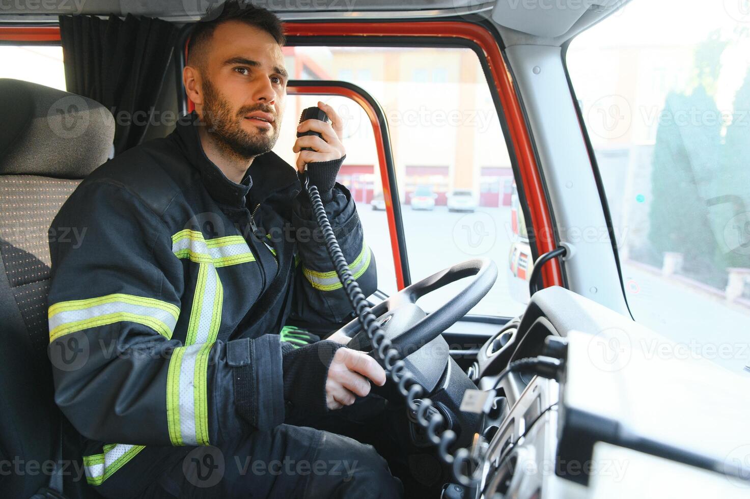 Firefighter using radio set while driving fire truck photo