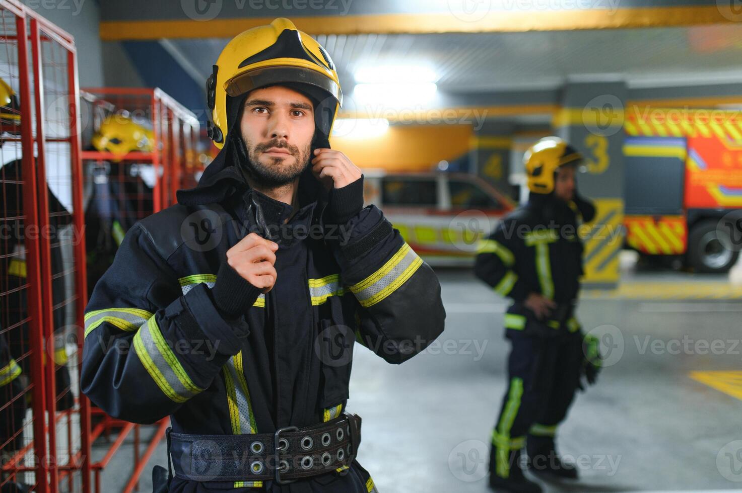 A firefighter puts on a fire uniform at the fire department photo