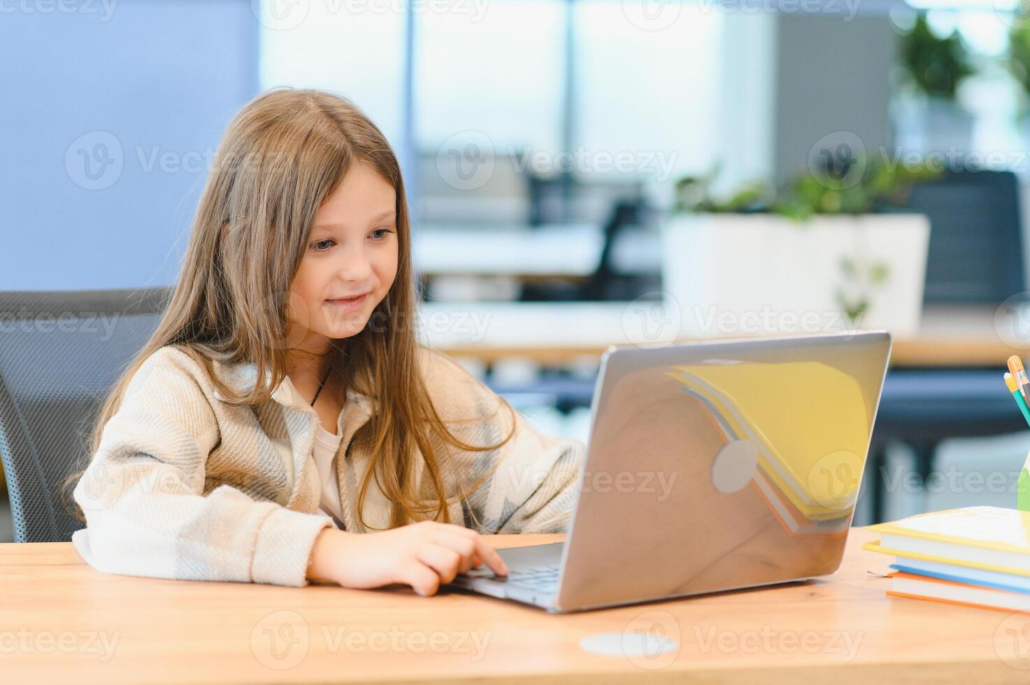 First day at school. Cute and happy little girl children using laptop computer, studying through online e-learning system photo