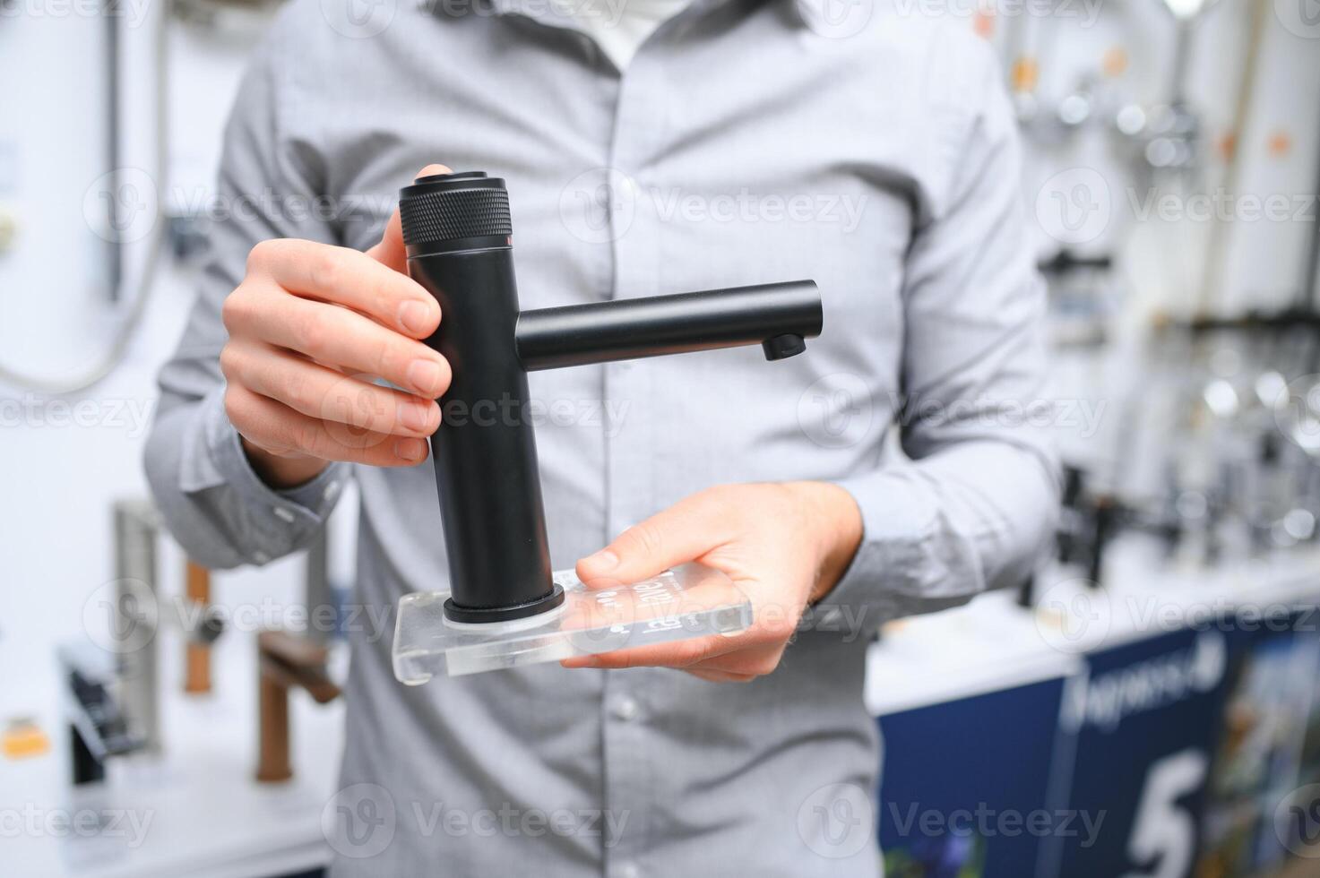 man choosing and touching faucet crane or water tap on shopping photo