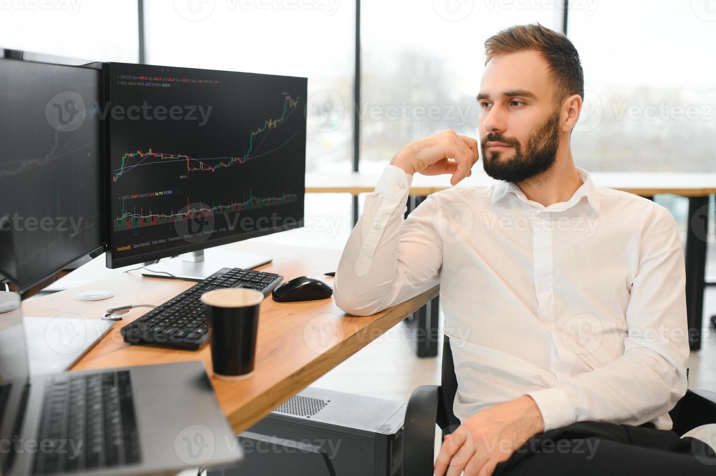 business man looking at the charts of the stock market of cryptocurrencies on the PC screen photo