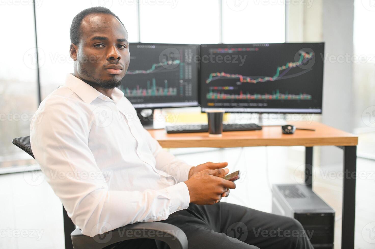 African-American broker works in office using workstation and analysis technology photo