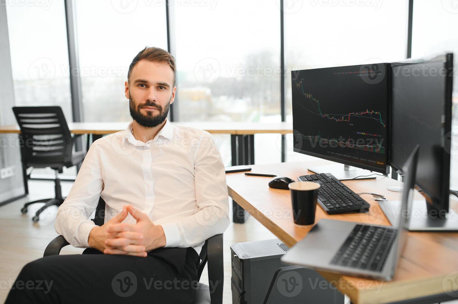 Crypto trader sits at his workplace in front of a monitor with charts. photo