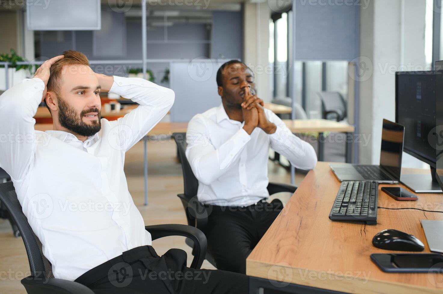 Two successful trader sitting in office, checking cryptocurrency information data on finance market graph, pointing on monitor photo
