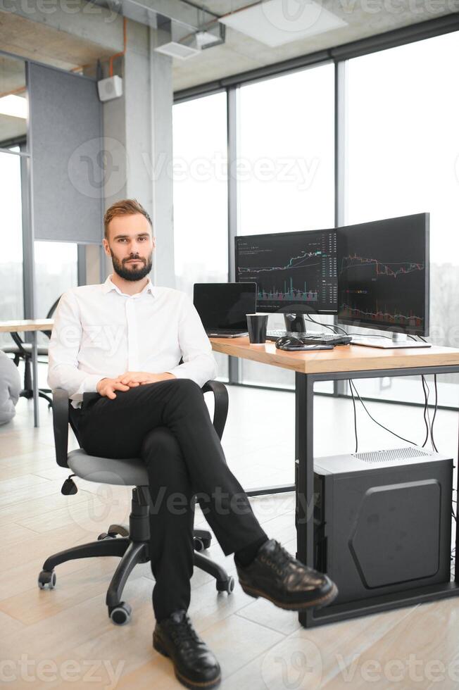 Financial Analysts and Day Traders Working on a Computers with Multi-Monitor Workstations with Real-Time Stocks, Commodities and Exchange Market Charts photo