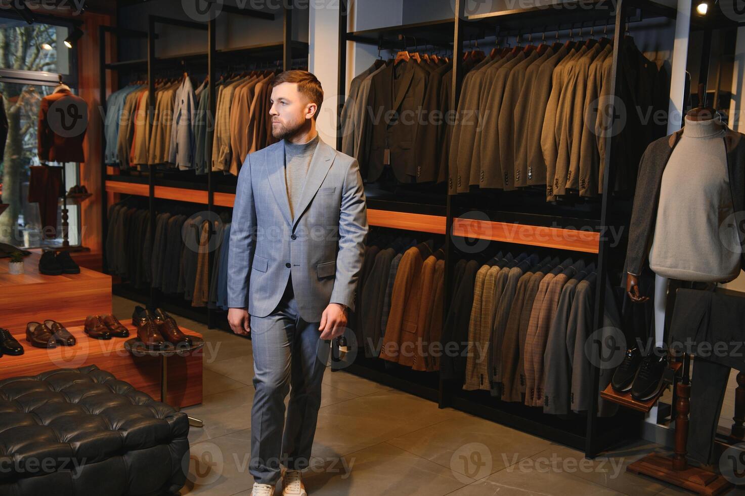 Modern young handsome businessman, looking and choosing classical suit in the suit shop photo