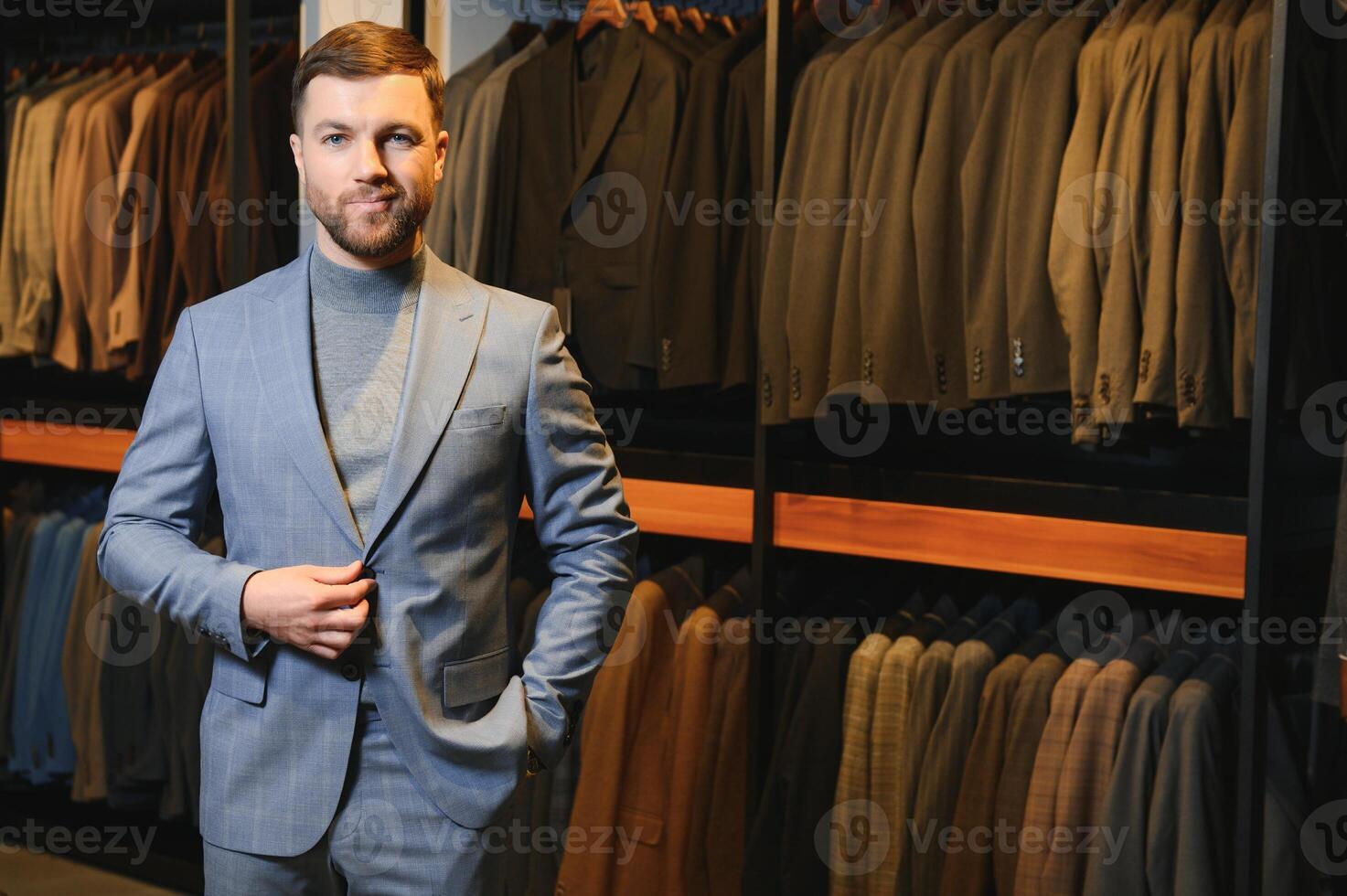 Modern young handsome businessman, looking and choosing classical suit in the suit shop photo