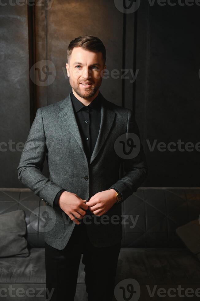Respectable handsome man in elegant suit in apartments with classical luxurious interior. Men's beauty, fashion photo