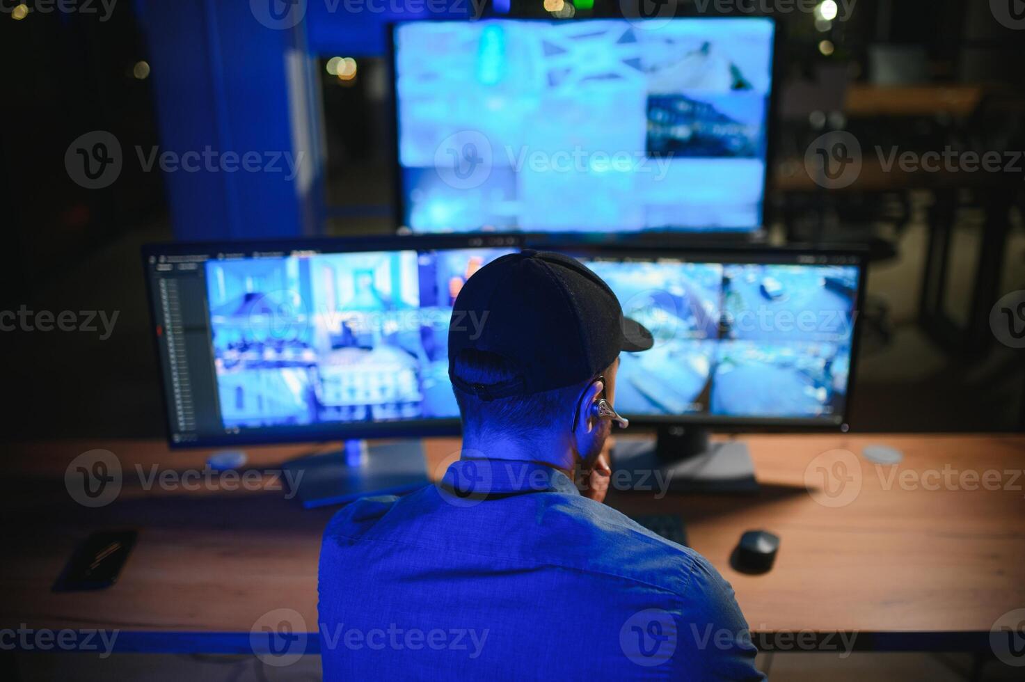 Security operator controls CCTV cameras in office at night. Modern security system and social safety concept photo