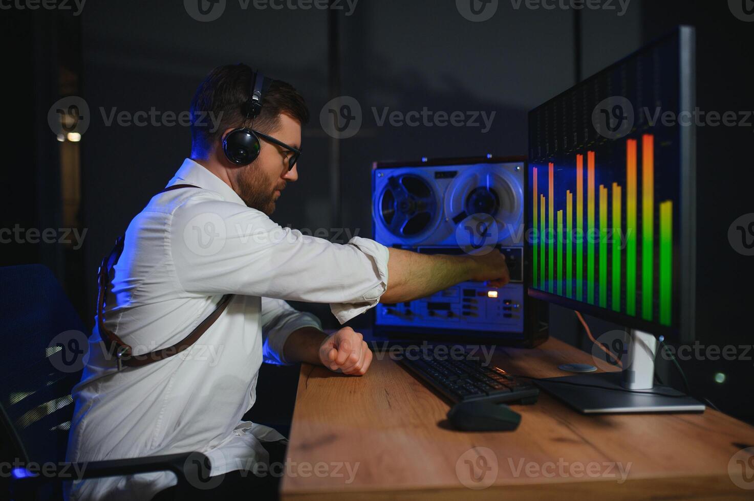 A male spy listens and records conversations on a reel-to-reel tape recorder photo