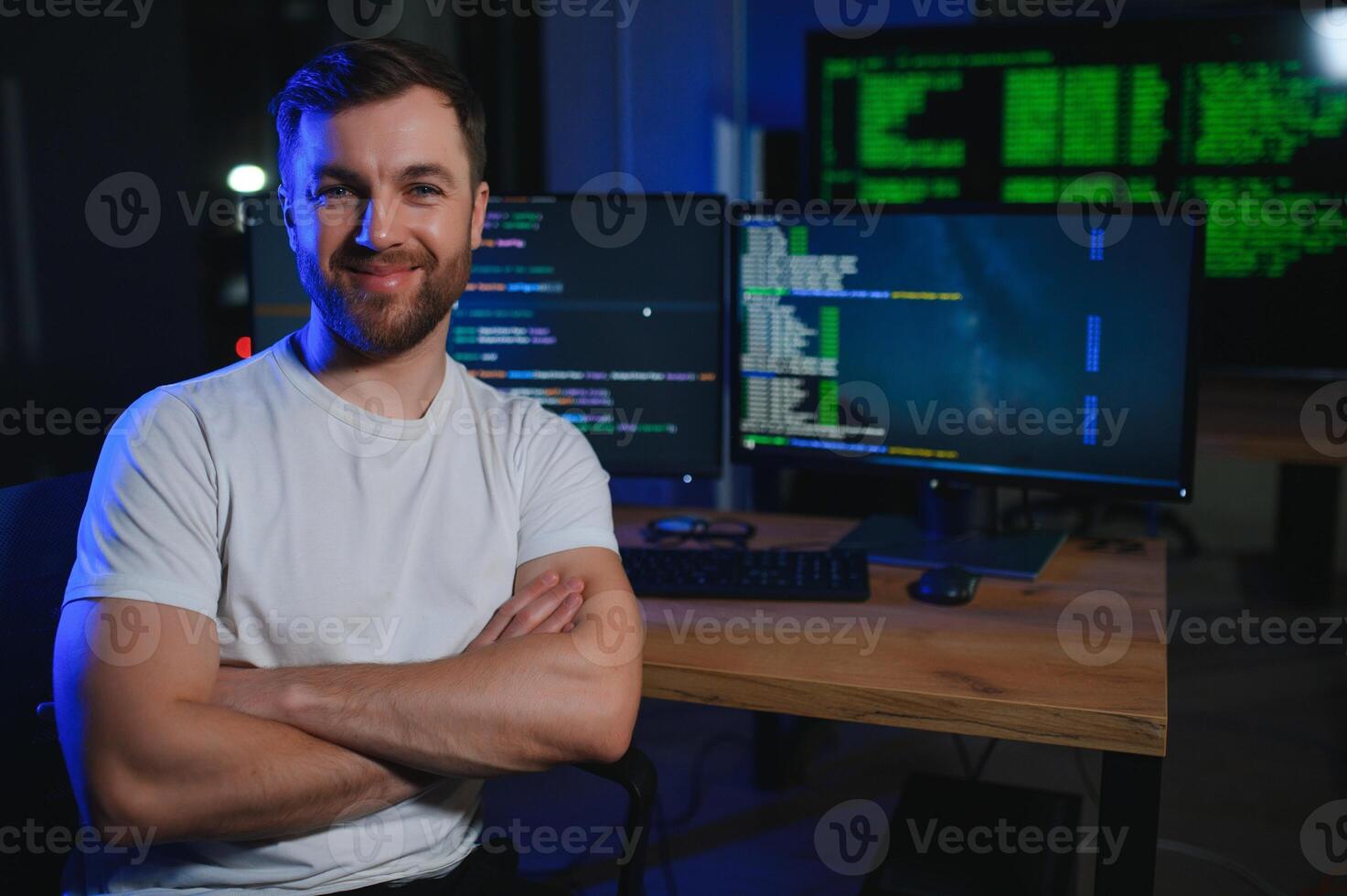Male programmer working on desktop computer at white desk in office photo
