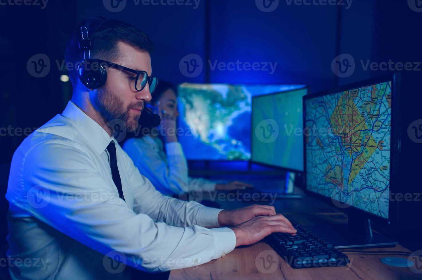 Male Data Scientist Works on Personal Computer Control and Monitoring Room. Map Surveillance of People Walking on City Streets photo