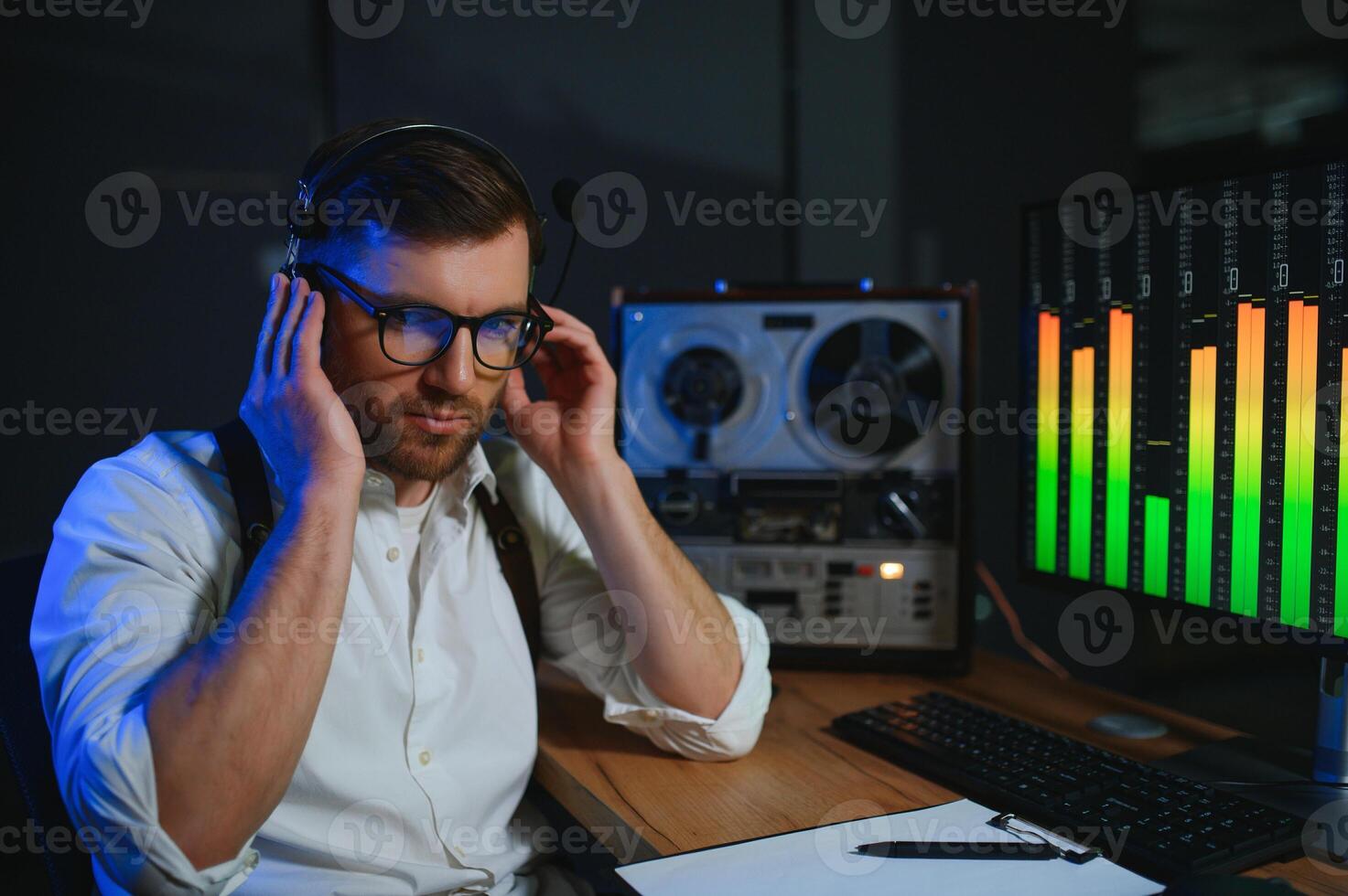 A male spy listens and records conversations on a reel-to-reel tape recorder photo