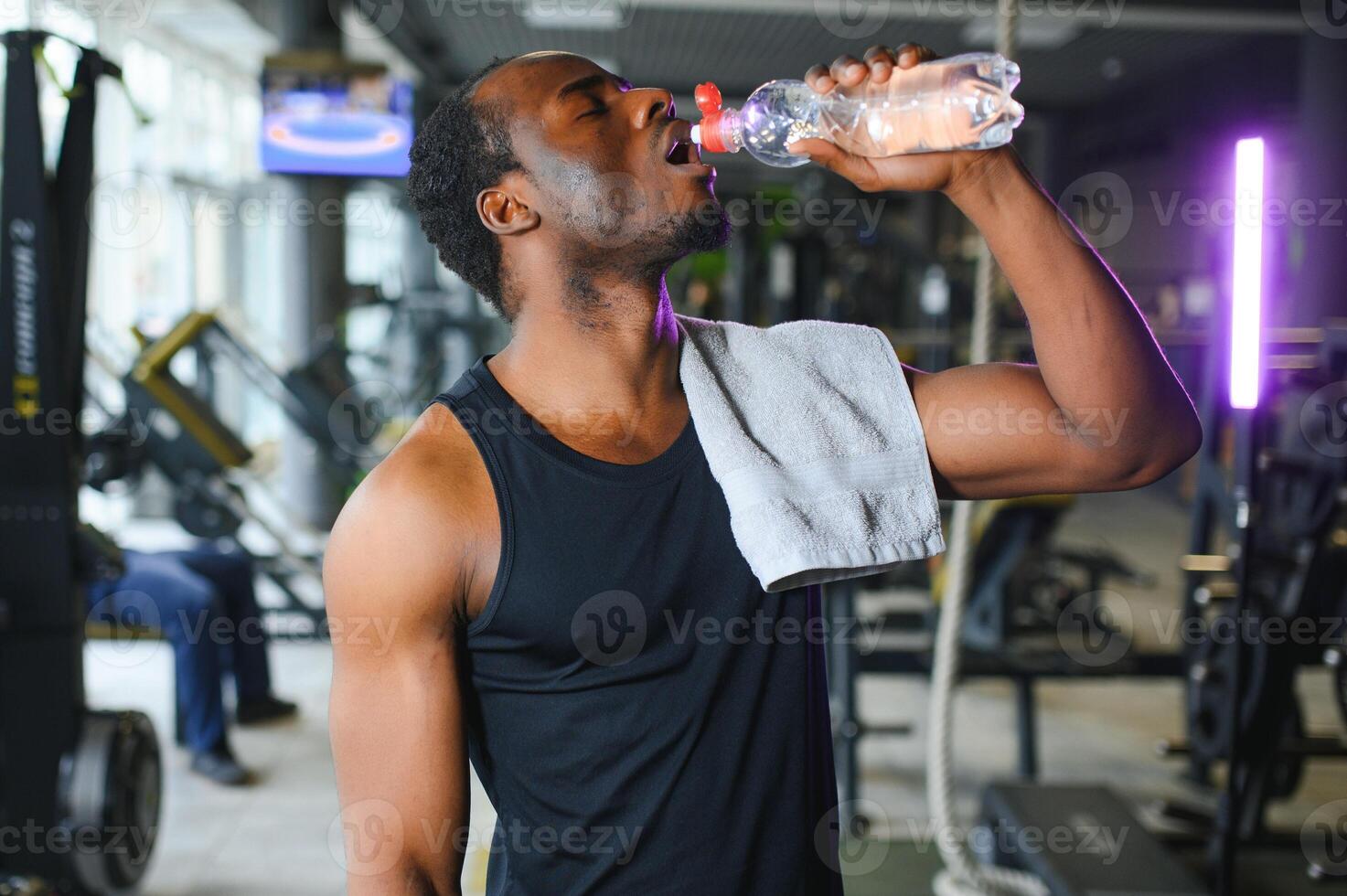 happy young african man drinking water after exercise photo
