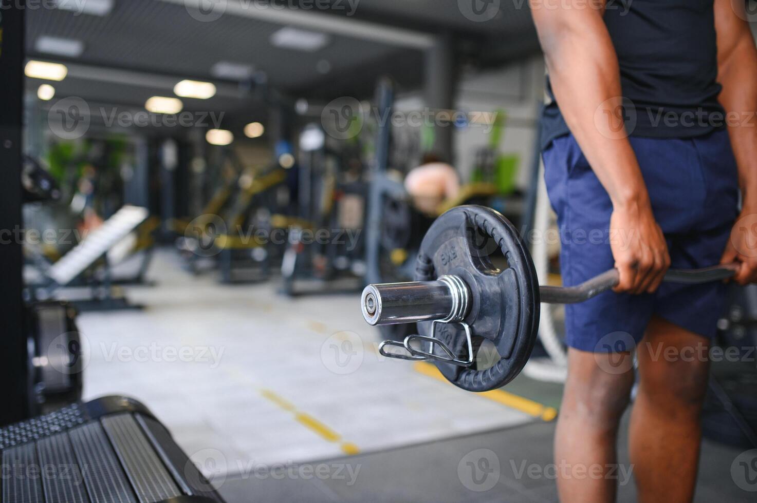 Athletic black guy making weightlifting or powerlifting at modern gym photo