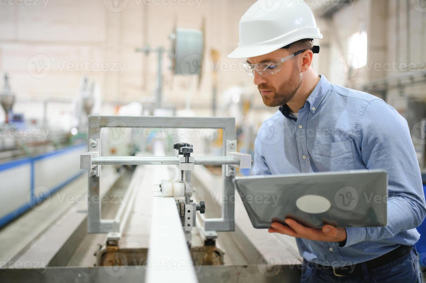 Side view of technician or engineer with headset and laptop standing in industrial factory photo