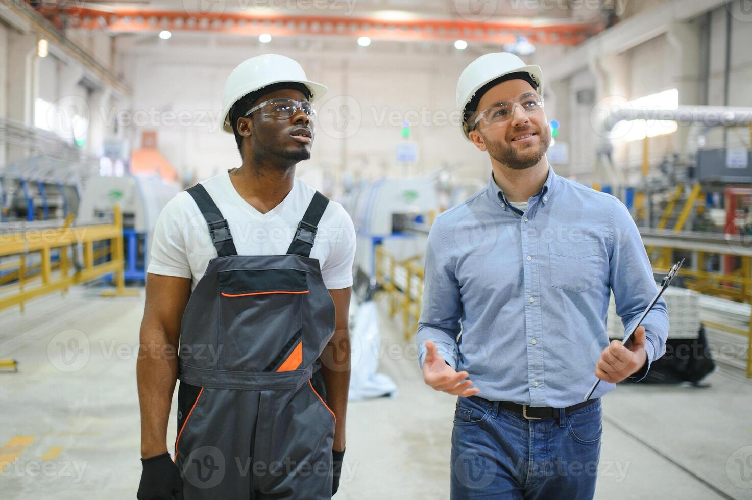 An engineer communicates with a worker on a production line photo