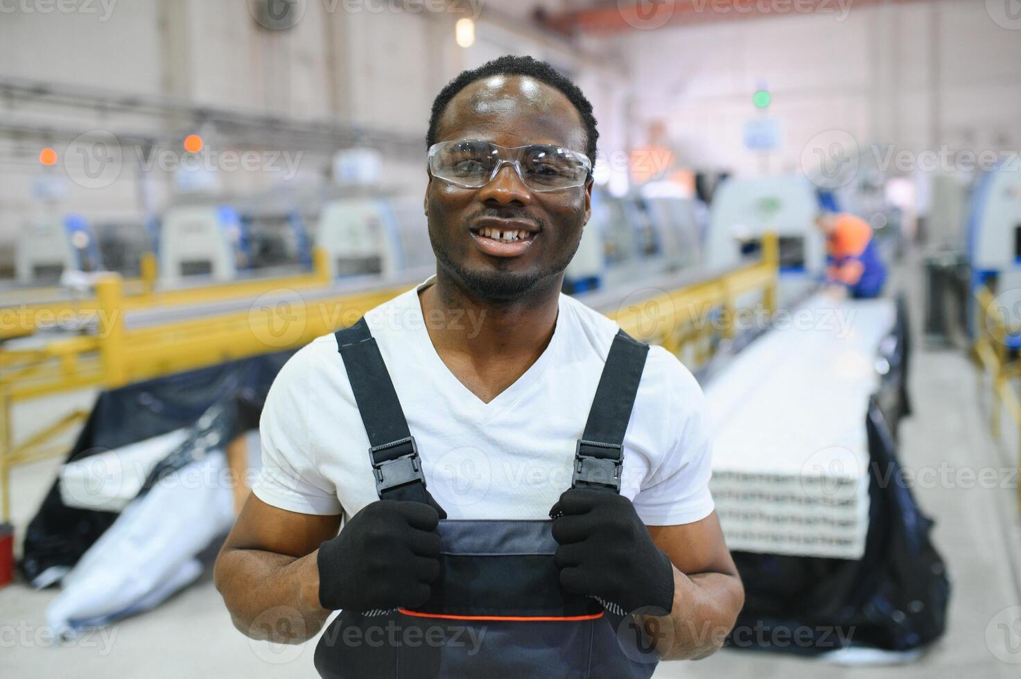 Portrait of African American male engineer in uniform and standing in industrial factory photo