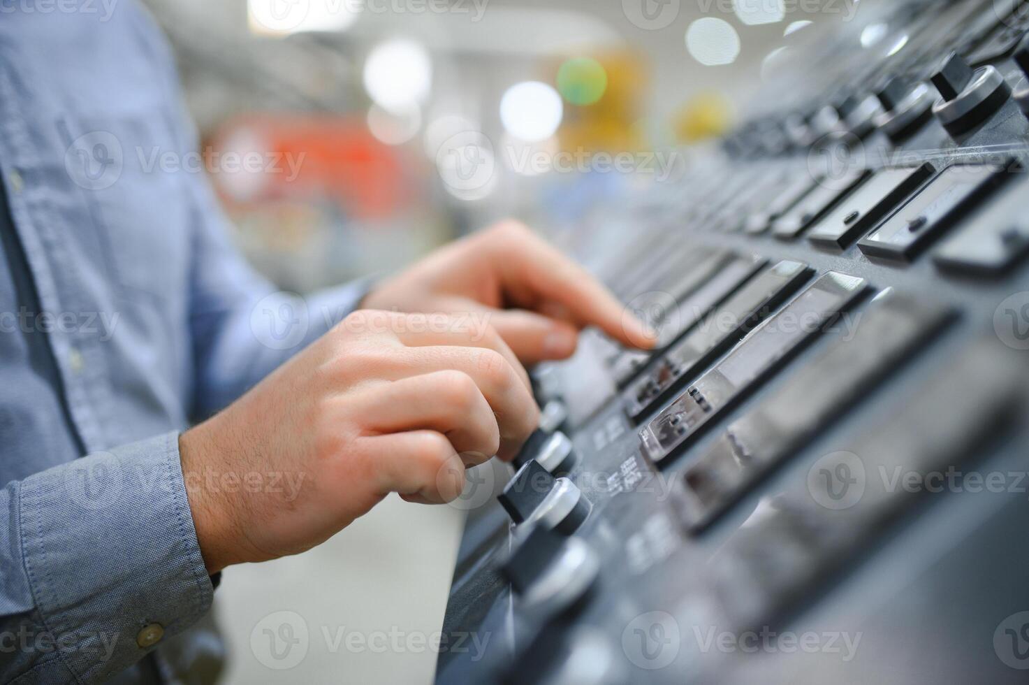 Hand of engineer turn power button on panel control machine photo