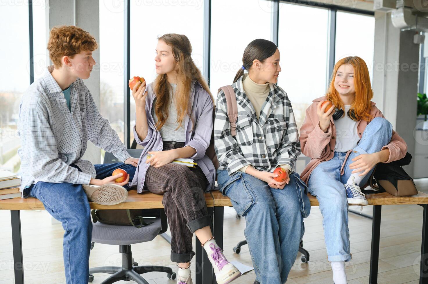 education, food, people and friendship concept, group of happy students eating apples photo