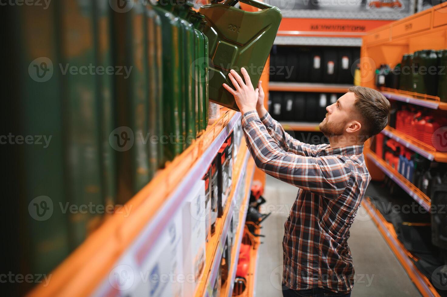 A male customer stands in an auto parts store with a jerry can photo
