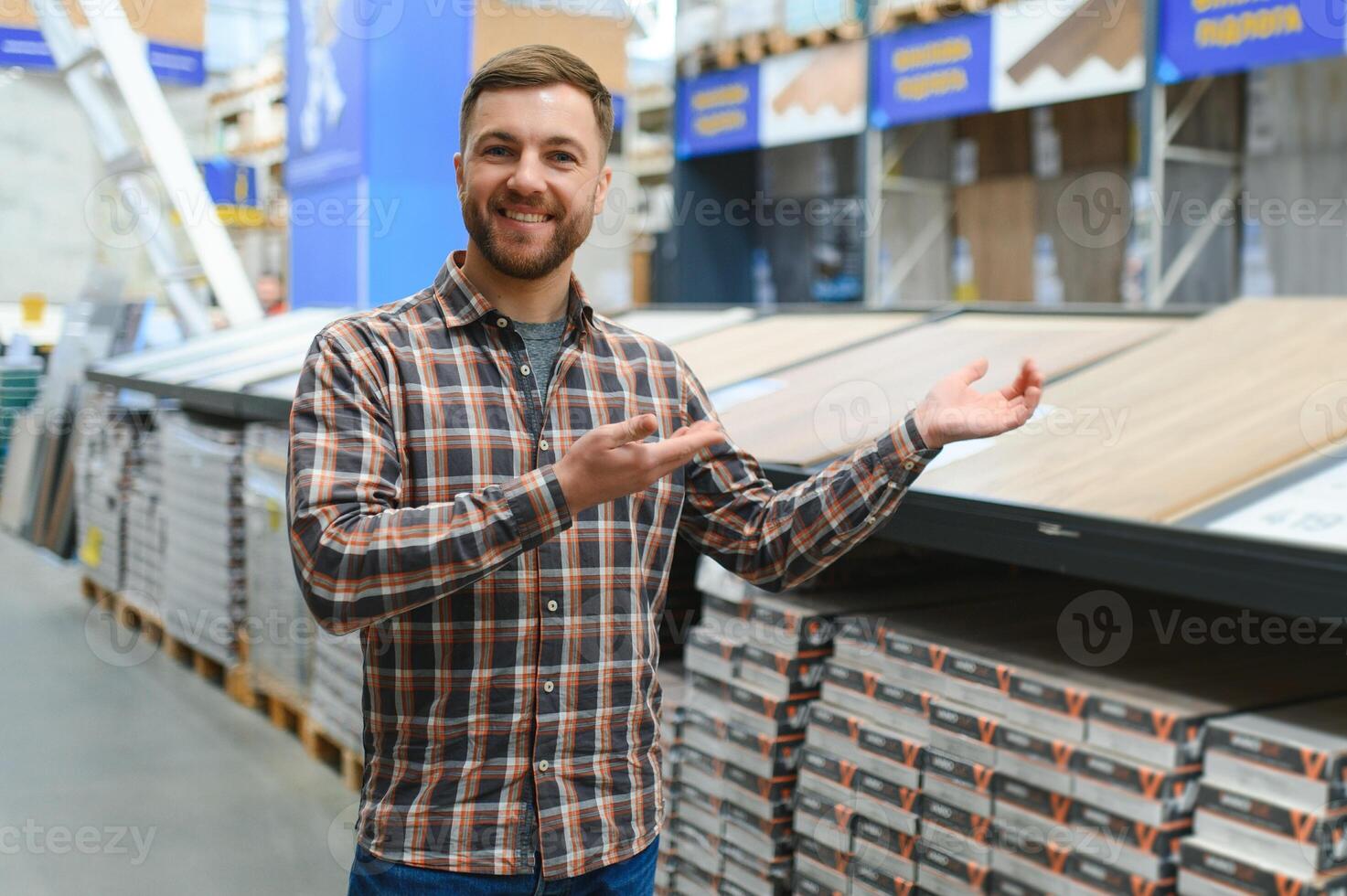 A male salesman-consultant in a hardware store sells laminate photo