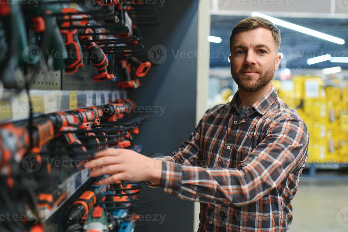handsome young man shopping for tools at hardware store photo