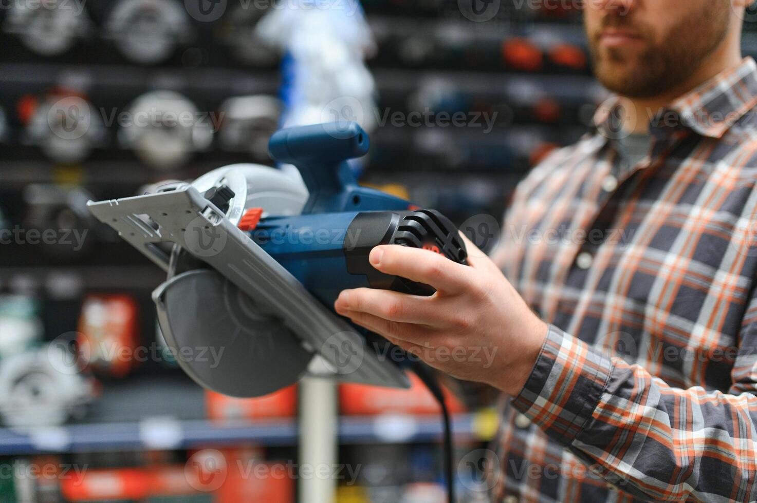 A man in a hardware store chooses a new orbital sander photo