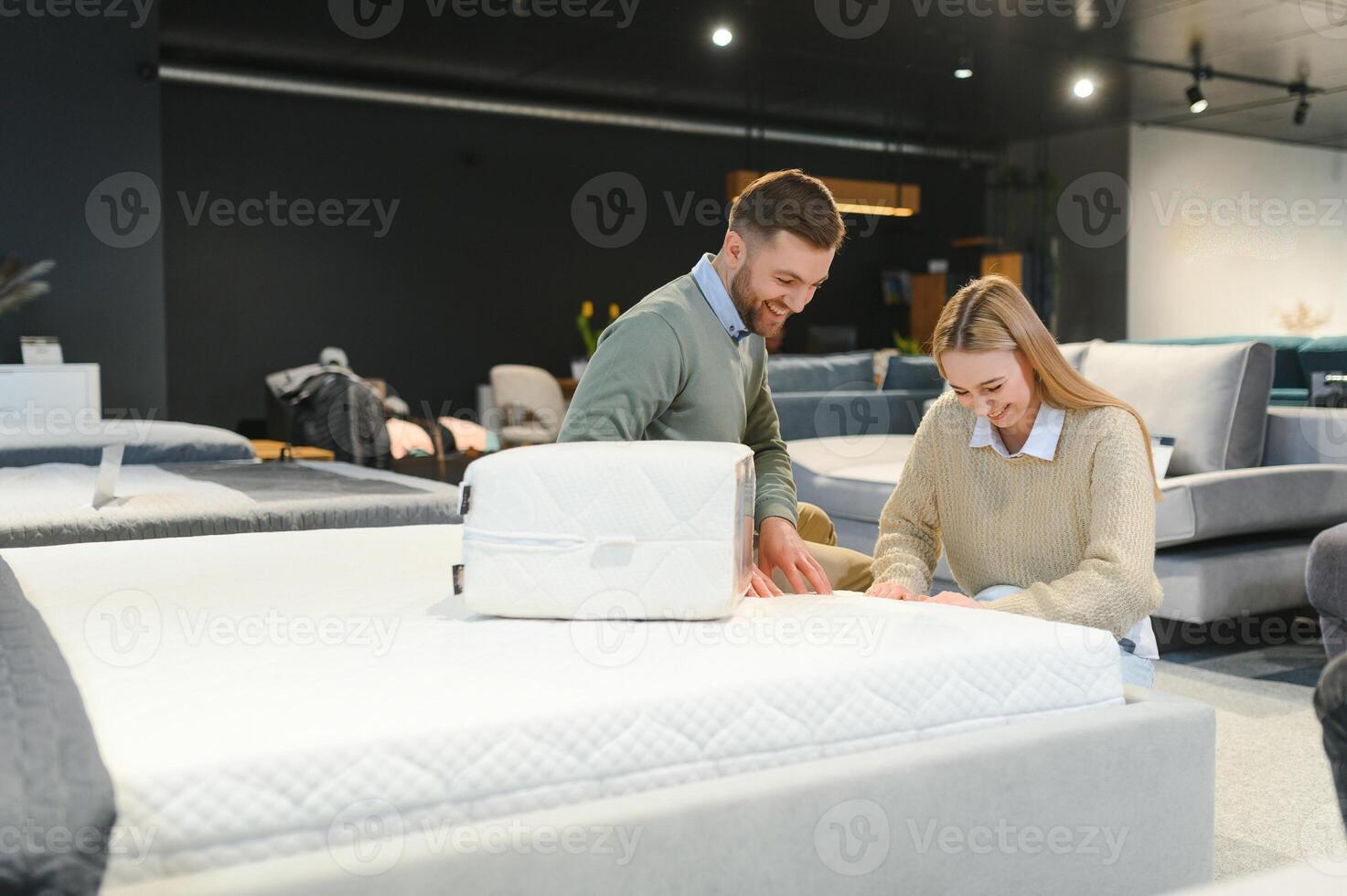 Couple buying new bed with orthopedic mattress in furniture store photo