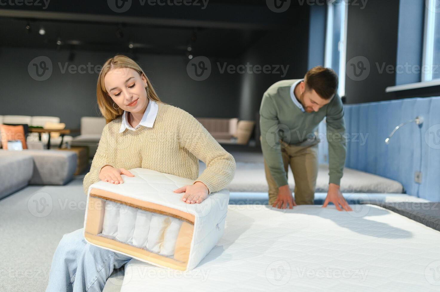 Couple buying new bed with orthopedic mattress in furniture store photo