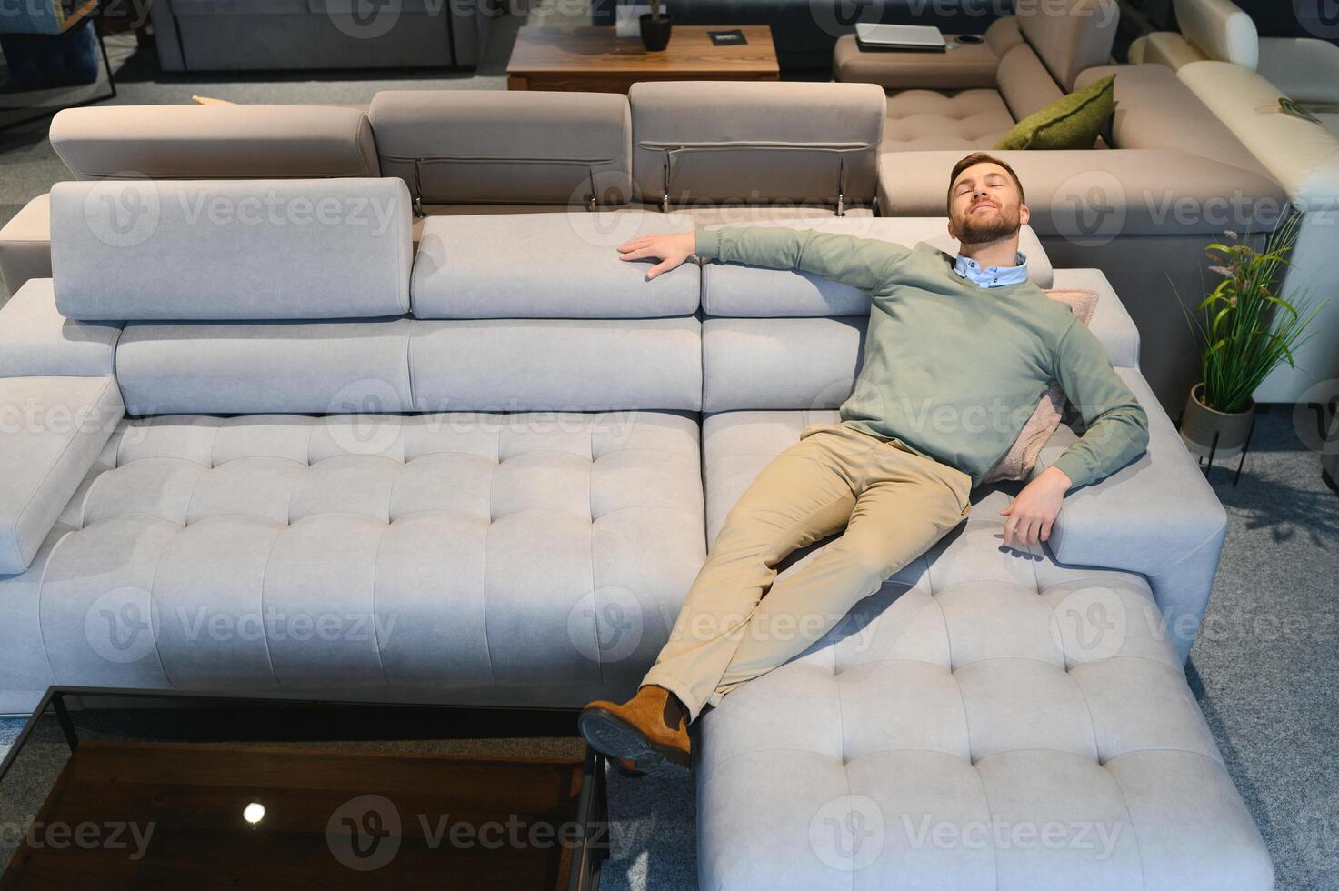 Young man buying sofa in furniture store photo