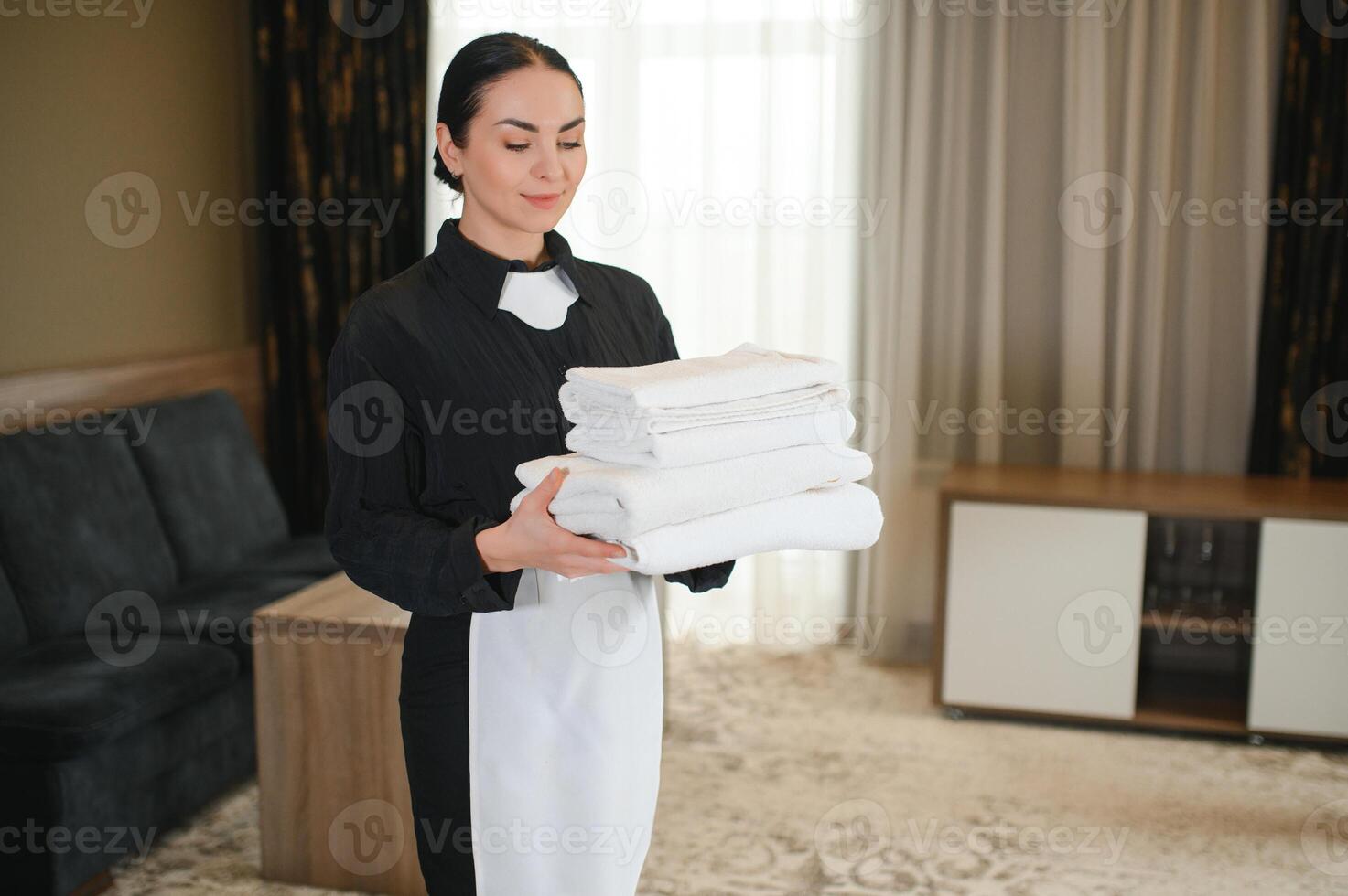 Housekeeper or Maid cleaning hotel room photo