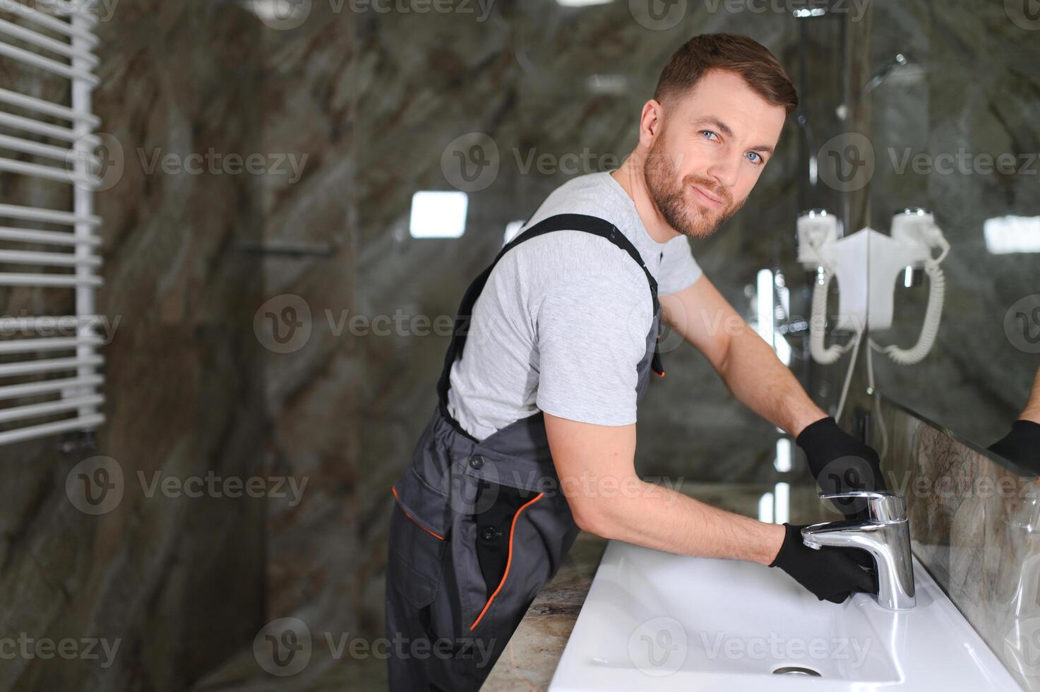 Plumber repairing the faucet of a sink photo
