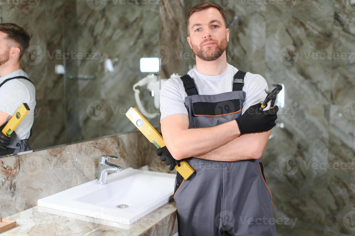 Plumber install sink in bathroom, checks even level of installation. Concept repair service plumbing photo