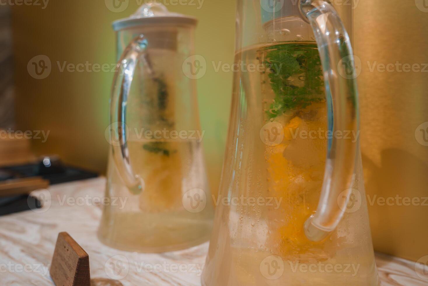 Elegant Glass Pitchers with Citrus and Herb Infused Water on Marble Countertop photo