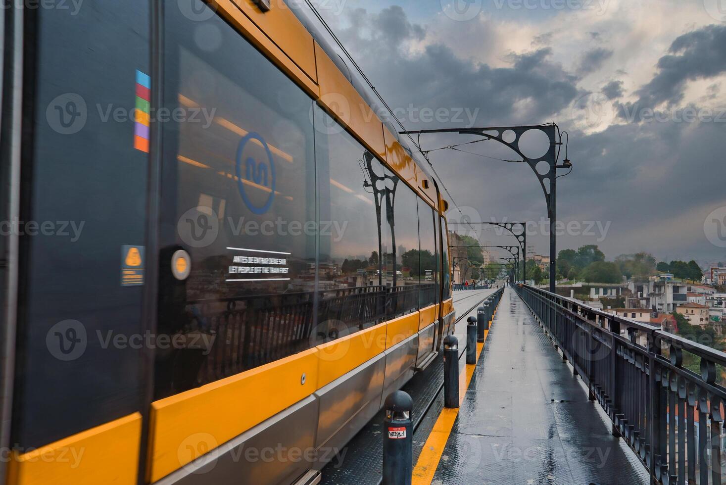 Yellow Metro Train on Dom Luis I Bridge in Porto on an Overcast Day photo