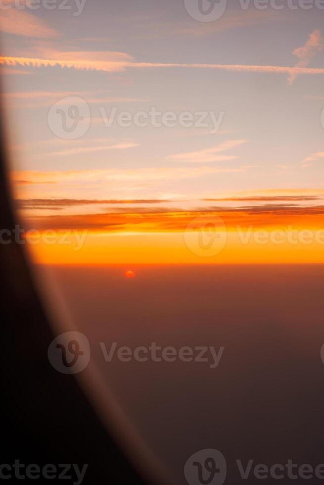 Enjoying the Sunset View from an Airplane Window While Soaring at High Altitude photo