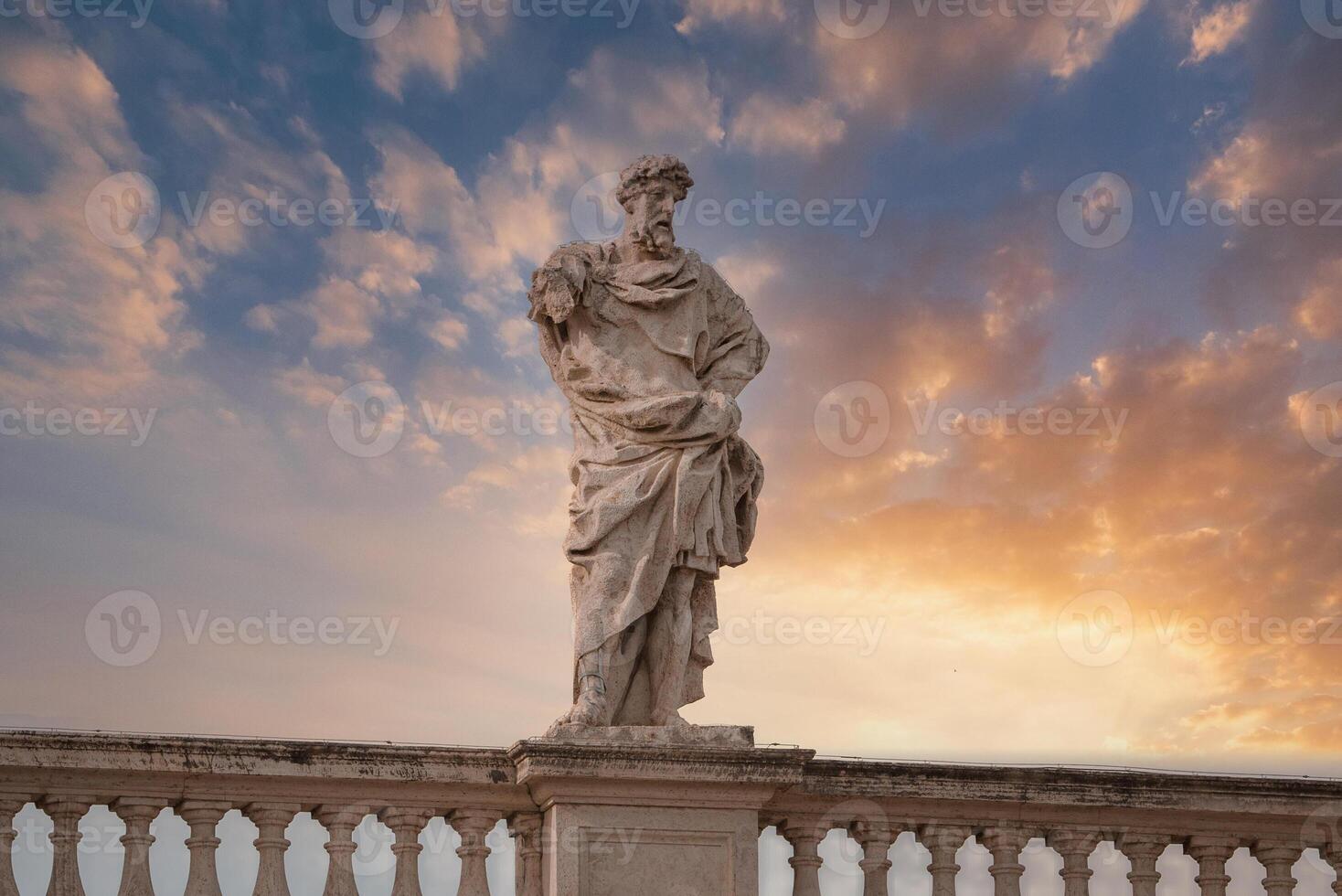 Classical statue at sunset in Vatican with dramatic sky photo