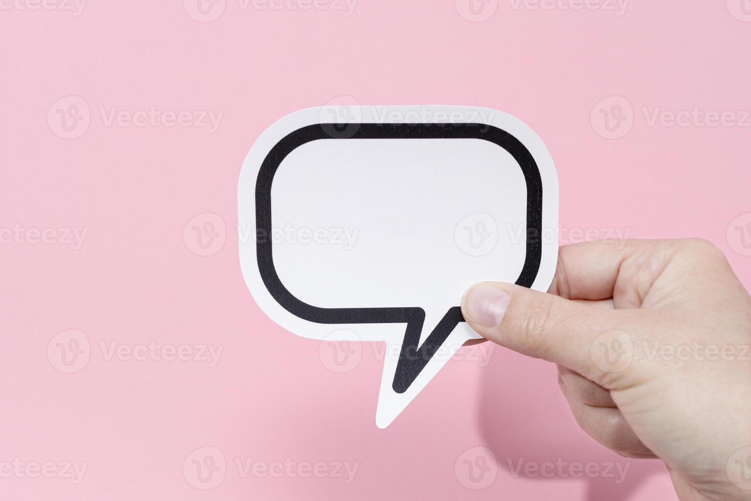 Hand holding a blank speech bubble isolated on pink background. Template Mockup photo