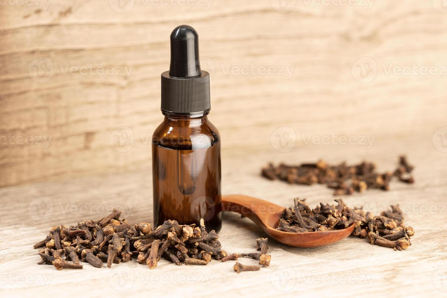 Clove essential oil still life. Amber glass bottle with pipette for skin care or aromatherapy. Copy space photo