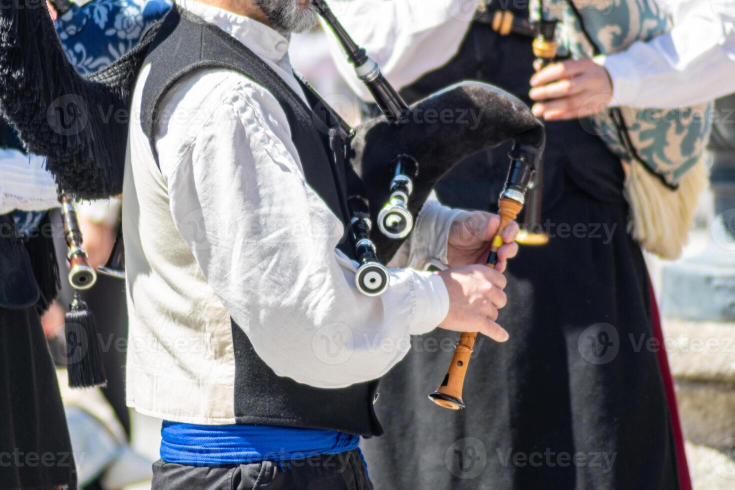 an unrecognizable man dressed in the typical costume playing the bagpipe in Galicia photo